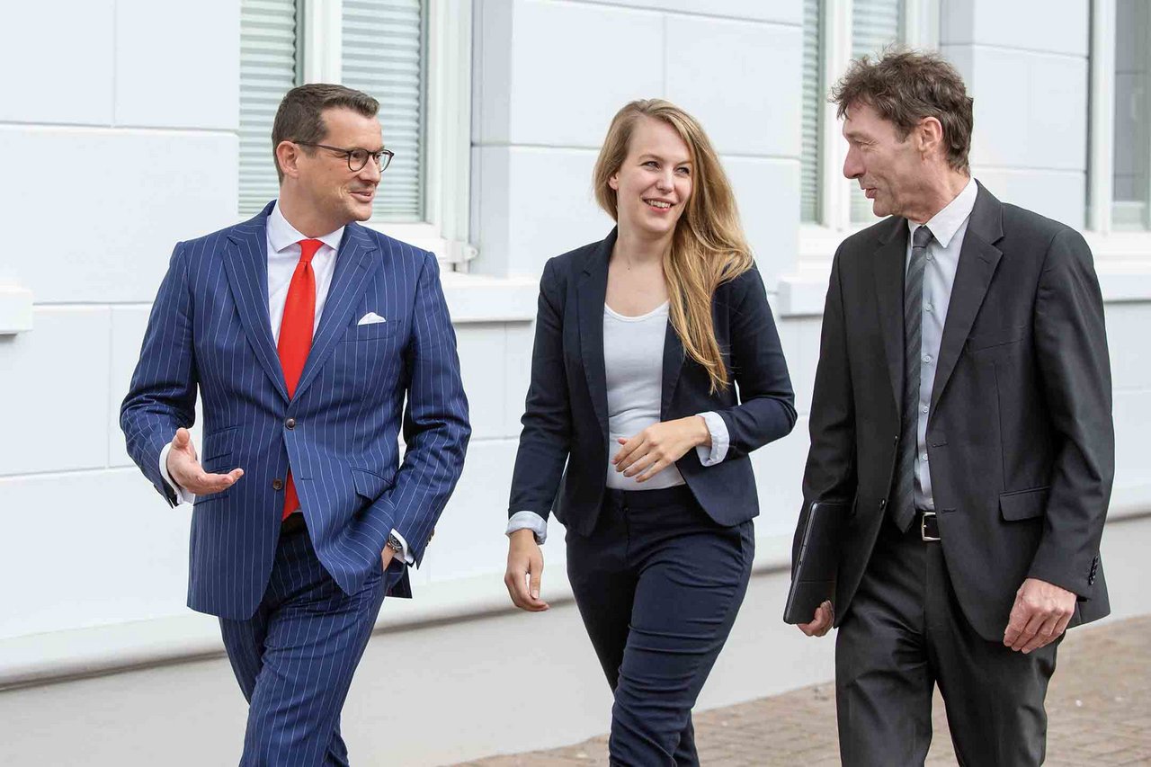 Dr. Malte Koester und Sabrina Beeneken im lockeren Austausch mit Kollegen vor Kanzlei